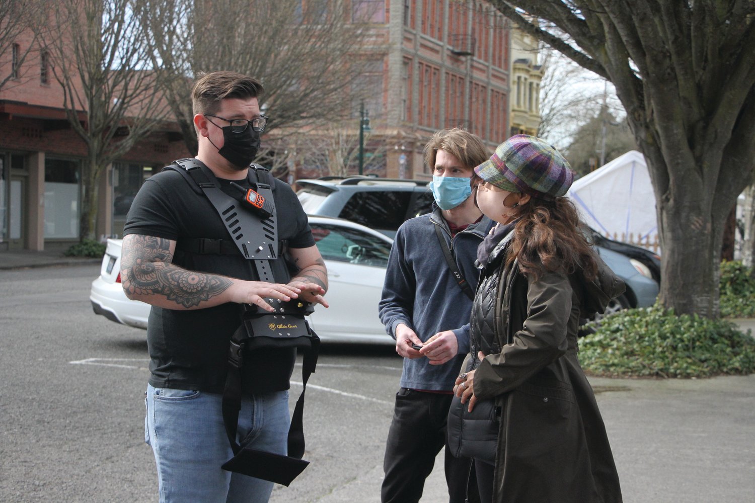 The cameraman and an assistant talk with Sundeen while the crew gets ready for filming on Washington Street.